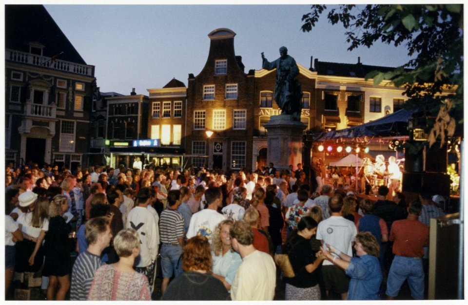 Publiek op de Grote Markt tijdens een optreden van de Amsterdamse rockband Buckwheat. Orientatie ziende naar het noordoosten