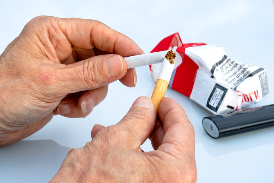 Cigarette between fingers cigarette überbrechen over a broken cigarette