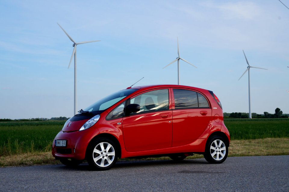 Public domain image - Peugeot iOn electric car in front of wind turbines