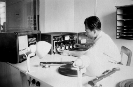 Radiostudio. Technicus draait aan knoppen. Voor hem grammofoonplatenspelers, Bestanddeelnr 7157