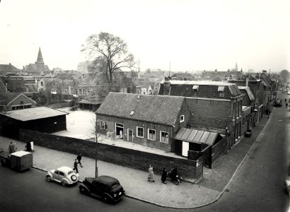 Raaks, ziende vanaf het postkantoor, naar het zuidoosten, en in de Jacobstraat. In de verte (achter de boom) is Vroom en Dreesmann aan het Verwult nog net te zien. De kerk links daarvan staat aan de G