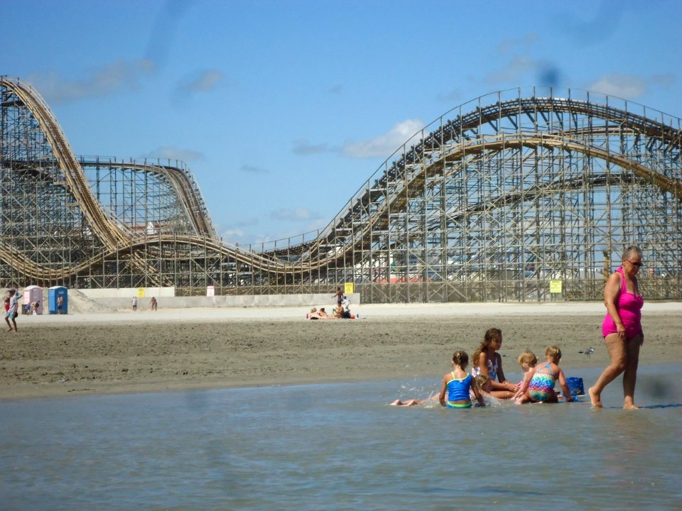 Roller coaster with people playing in sand