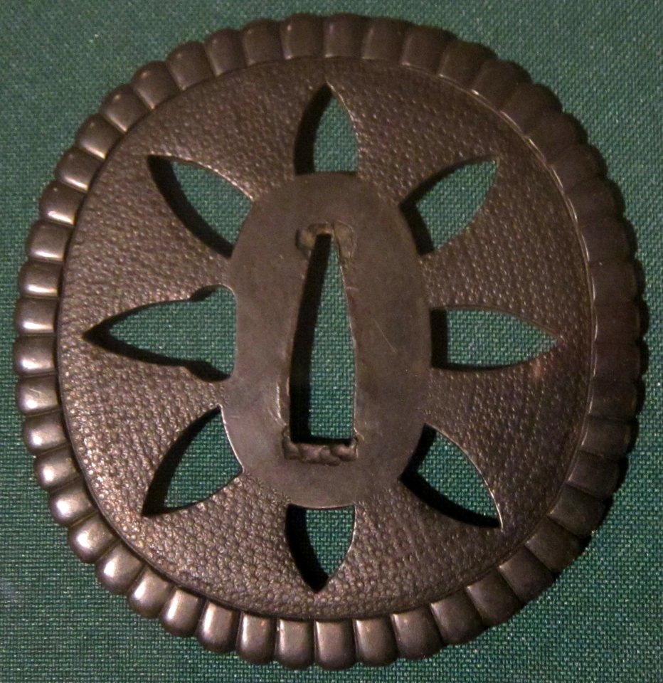 Round sword guard with Buddhist motif, early 16th century, copper and shakudo
