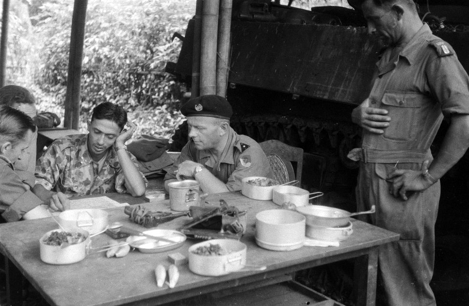 Rond de tafel zitten militairen waaronder een KNIL onderluitenant van een Eskad, Bestanddeelnr 3700