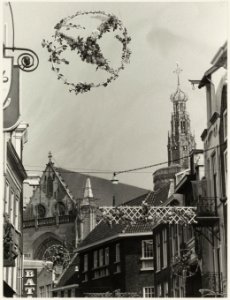 Restauratie van de toren van de Grote Kerk gezien vanuit een versierde de Grote Hout, NL-HlmNHA 54012100