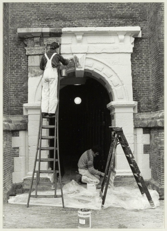 Restauratie van de toren van de Nieuwe Kerk. Schilders leggen de laatste hand aan het portaal van de kerk. Rechts Henk Pas, links Dirk van der Meij van Schildersbedrijf Rijs. NL-HlmNHA 54011447