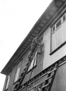 Reykjavik Man op ladder reinigt gevelplaten van een woonhuis, Bestanddeelnr 190-0446