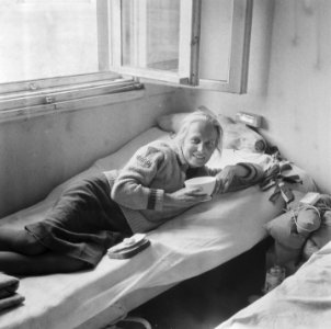 Repatriante ligt op een bed met in haar handen een kom en op bed stukken brood, Bestanddeelnr 900-5087 photo