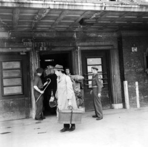 Repatrianten met bagage verlaten station, Bestanddeelnr 900-5072