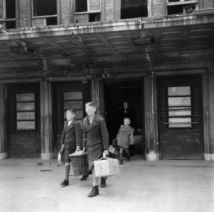 Repatrianten met bagage verlaten station, Bestanddeelnr 900-5073