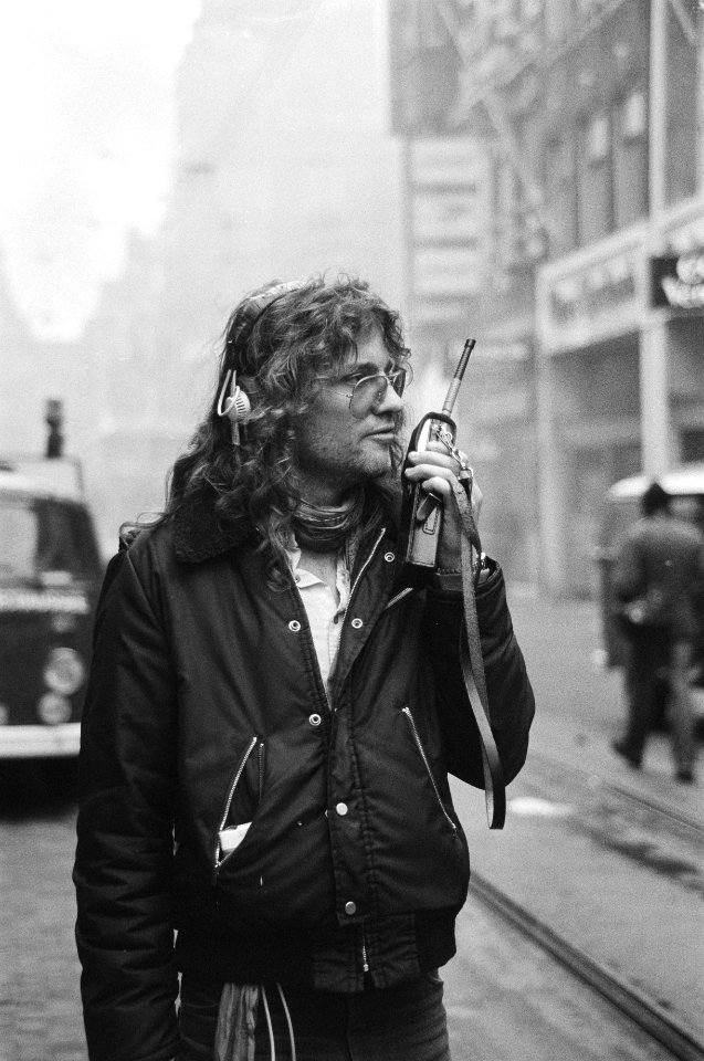Reporter Stan van Houk van radiostad Amsterdam met portofoon, Bestanddeelnr 931-3119