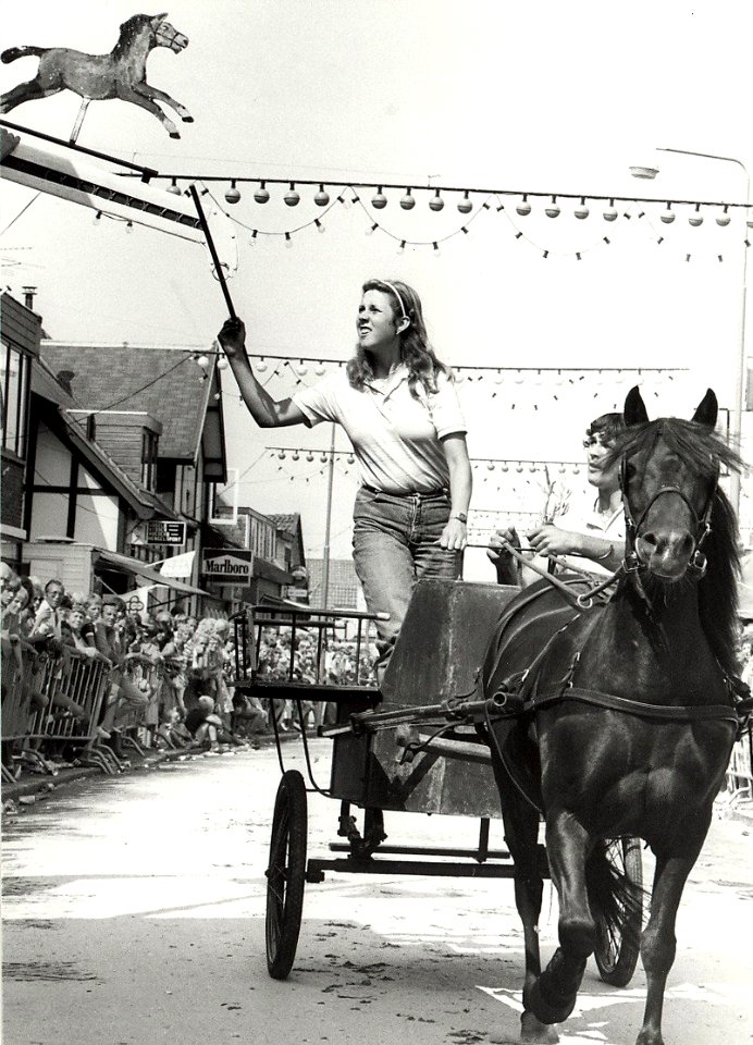 Ringsteken tijdens de feestweek, in de Hoofdstraat. Aangekocht in 1983 van fotograaf C. de Boer. - Negatiefnummer 22157 k 6 a. - Gepubliceerd in het Haarlems Dagblad van 04.08.1982, NL-HlmNHA 54013081
