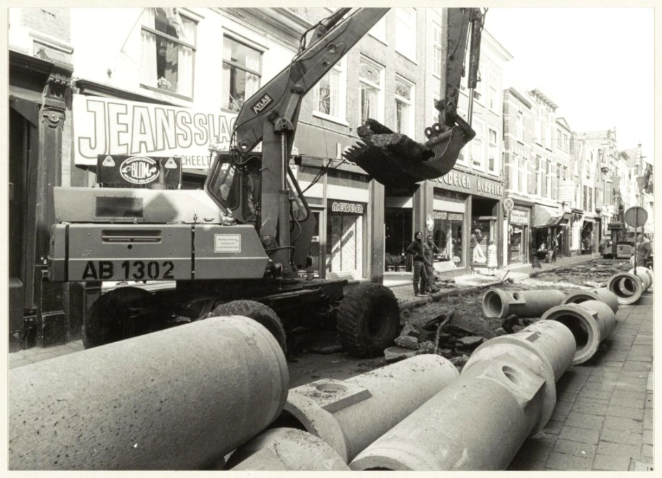 Rioleringswerkzaamheden in de Kleine Houtstraat in verband met het afsluiten voor het verkeer waarna er sierbestrating zal worden aangeled. NL-HlmNHA 54010012