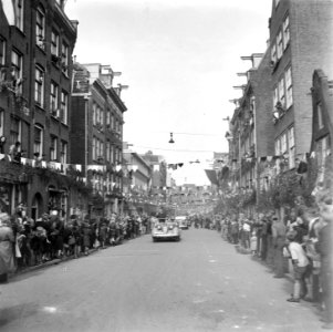 Rijtoer van koningin Wilhelmina door Amsterdam. In de eerste auto staat rechtop, Bestanddeelnr 900-4567