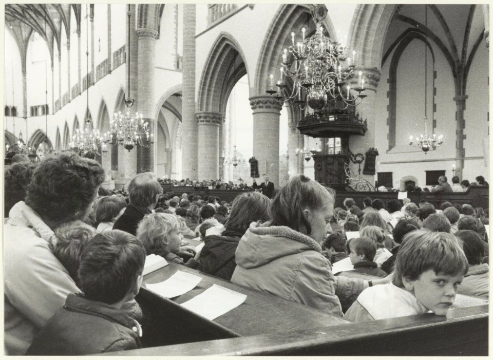 Samenzang door scholieren in de Grote of St. Bavokerk. NL-HlmNHA 54025681