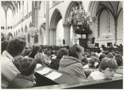 Samenzang door scholieren in de Grote of St. Bavokerk. NL-HlmNHA 54025681