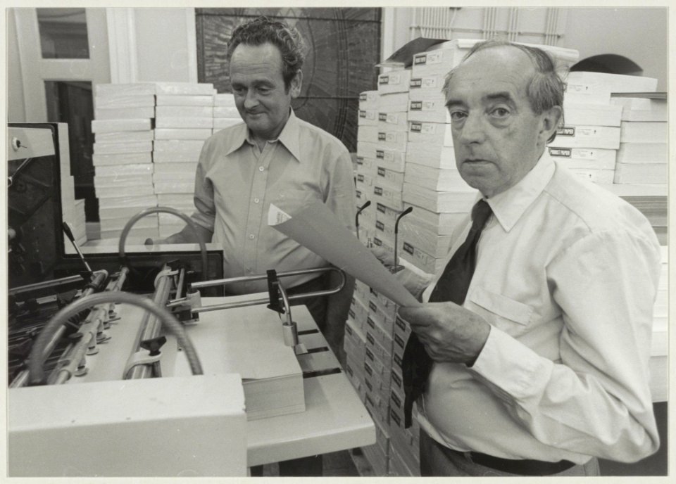 Samen met drukker Rinus Raaijmakers van de stadsdrukkerij bekijkt Henk Duits (rechts) de eerste druk van het gemeentelijk blad Wijk in Wijk uit, dat zojuist van een van de moderne offsetpers, NL-HlmNHA 54011366