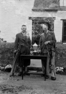 Two men with golf clubs and a cup (1293679)