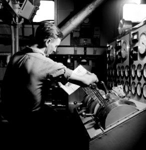 Tweede machinist bij het bedieningspaneel van de motoren in de machinekamer van…, Bestanddeelnr 254-1367