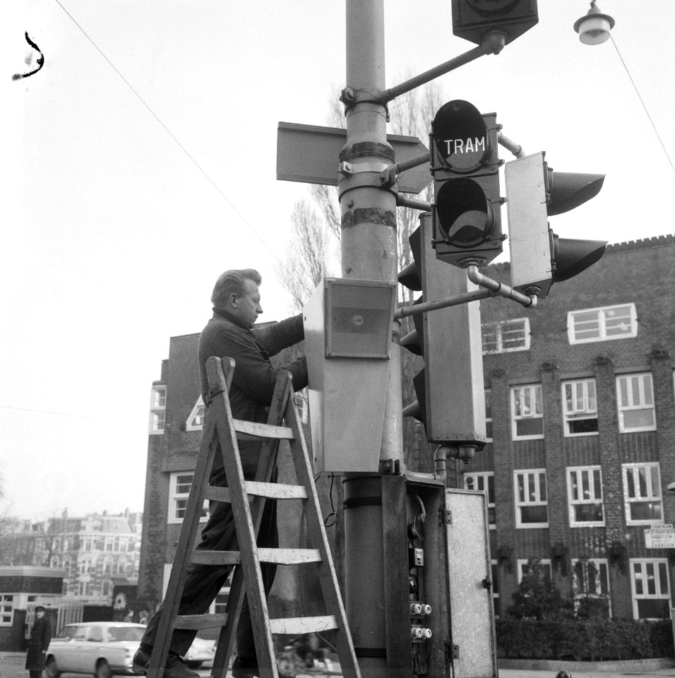 Trampraatpalen in Amsterdam in februari in gebruik, bezig om hangende luidspreke, Bestanddeelnr 917-3569
