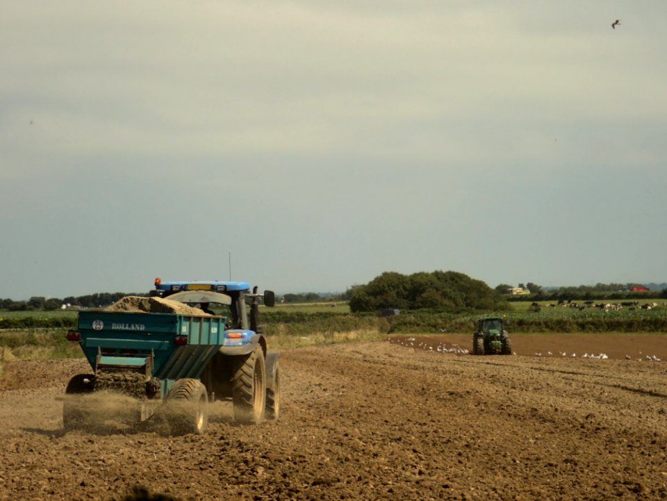 Tractors cultivating and fertilizing a field in Brittany 02