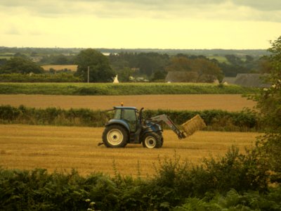 Tractor picking up bale