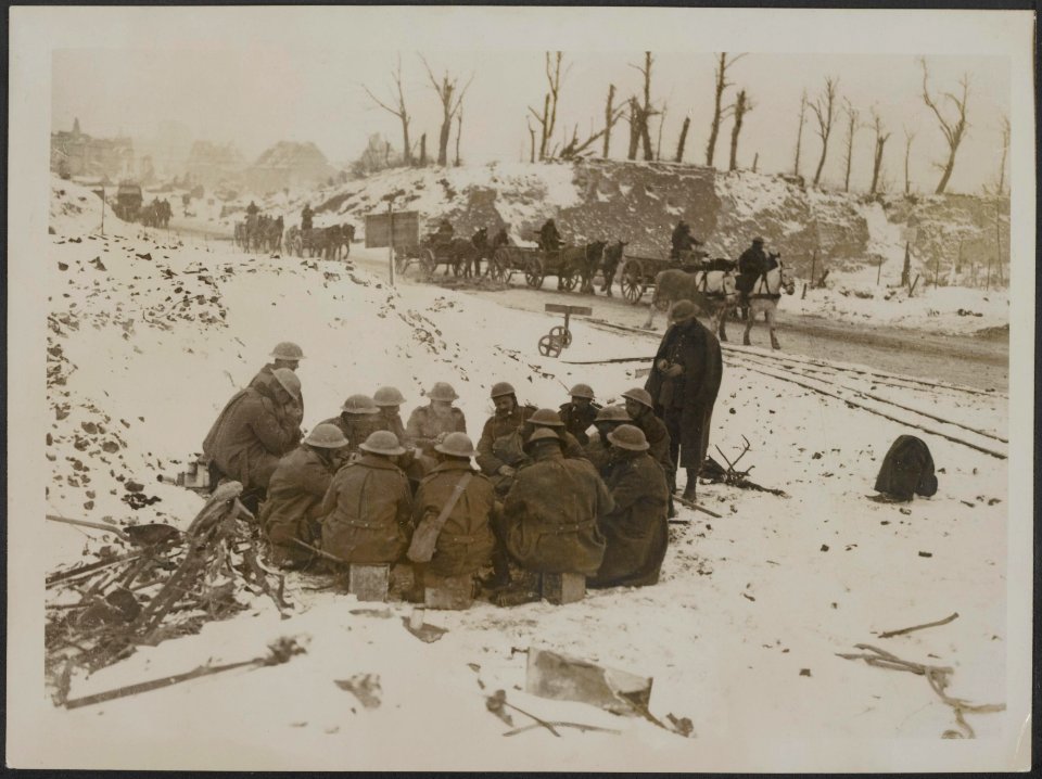 Troops warming themselves in front of a fire by the roadside, Bestanddeelnr 158-2346