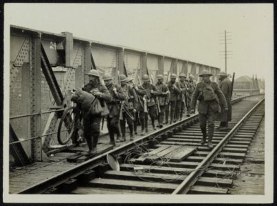 Troops passing over a bridge which is mined ready to blow up should it be necess, Bestanddeelnr 158-0945