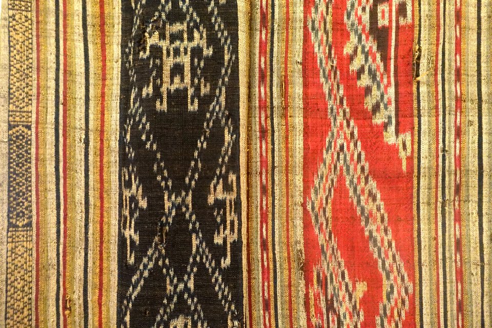 Tubular skirt detail, Thai Den, Son La, 1945, ikat with red and indigo background, woven patterns with extra threads - Vietnamese Women's Museum - Hanoi, Vietnam - DSC03903