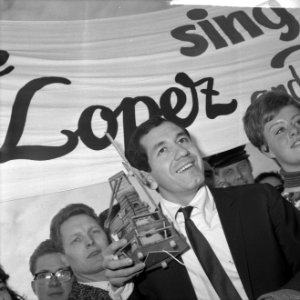 Trini Lopez op Schiphol krijgt een molentje aangeboden door Volendamse schone, Bestanddeelnr 916-0278