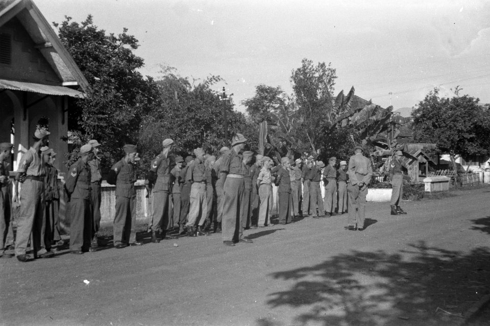 Troepen staan aangetreden langs de kant van de weg. Een officier spreekt ze toe, Bestanddeelnr 362-2-3