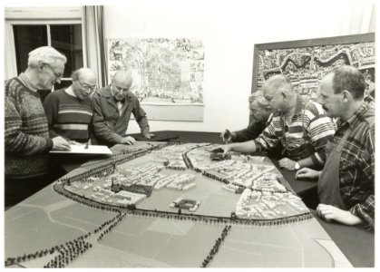Van links naar rechts de heren Cees Zon, Wim van de Water, Ate Bloemsma, Gé Fortgens, Hans van Roo en Cees van Zon aan het werk aan de maquette van Haarlem volgens de kaart van Nautz uit 182, NL-HlmNHA 54035109