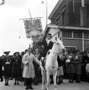 Vaandeldraagster van de VVSL te paard voor het station, Bestanddeelnr 900-7844