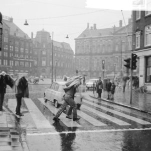 Vakantie begonnen, mensen in de regen op Dam, Bestanddeelnr 917-9735