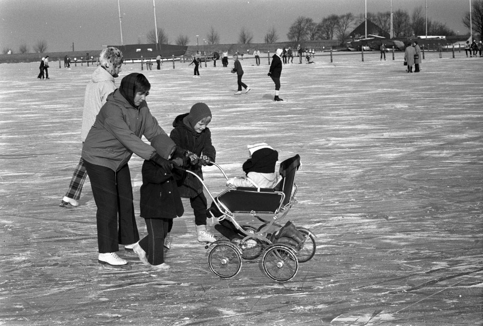 Veel schaatsers op Gouwzee, moeder op schaatsen met kinderwagen, Bestanddeelnr 925-3483