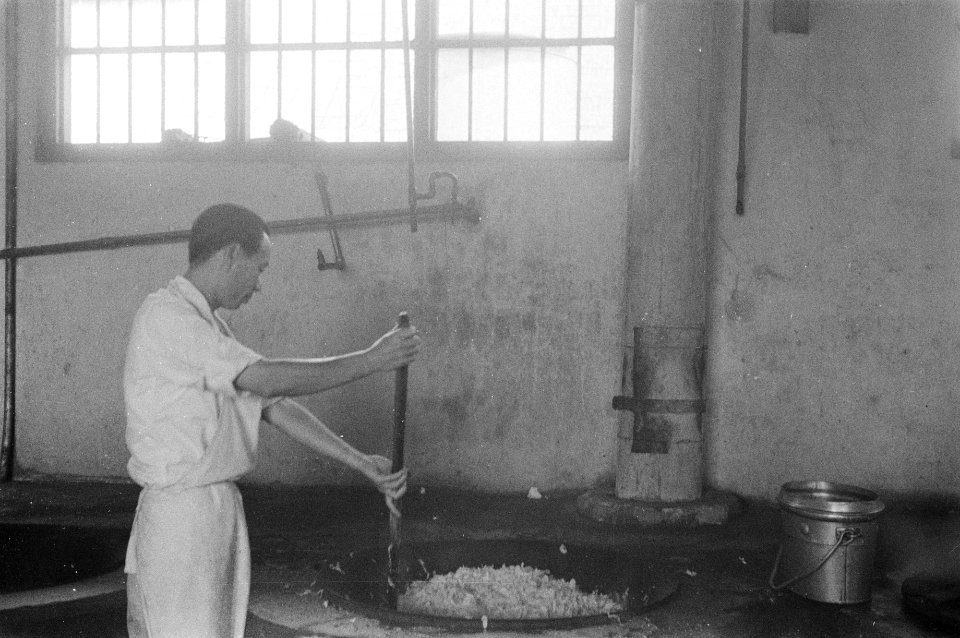 Veldkeuken, een inheemse man roert in een grote wadjan, Bestanddeelnr 170-5-1
