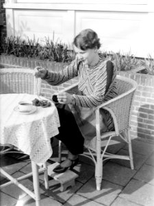 Van de Polls vrouw Nell Langlais aan het borduren op een terras bij Duin en Daal, Bestanddeelnr 189-1288