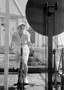 Van de Polls vrouw Nell Langlais op een krachtfiets op het cruiseschip MS Colomb, Bestanddeelnr 190-0102