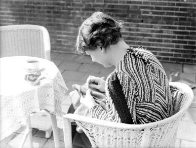 Van de Polls vrouw Nell Langlais aan het borduren op een terras bij Duin en Daal, Bestanddeelnr 189-1291