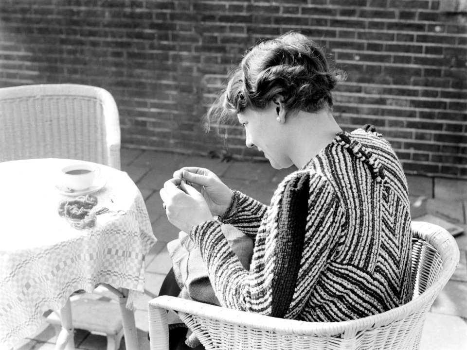 Van de Polls vrouw Nell Langlais aan het borduren op een terras bij Duin en Daal, Bestanddeelnr 189-1292