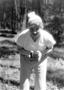 Van der Polls vrouw Nell Langlais met fototoestel in een bos op de Veluwe, Bestanddeelnr 189-0498