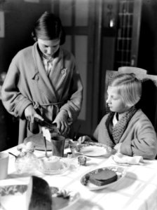 Van de Polls stiefdochters poseren voor een ontbijtscène Hans snijdt brood, Ren, Bestanddeelnr 189-0964
