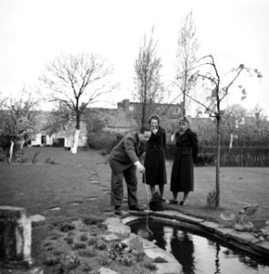 Van de Polls stiefdochters Renée en Hans met de heer Numann in zijn tuin, Bestanddeelnr 252-1915