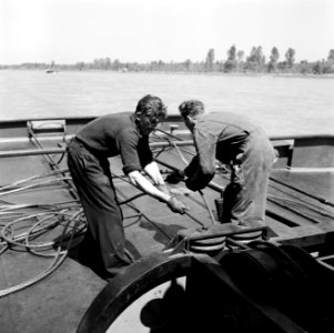 Vastmaken van een binnenvaartschip aan de Damco 230 met links bemanningslid Jan…, Bestanddeelnr 254-1603