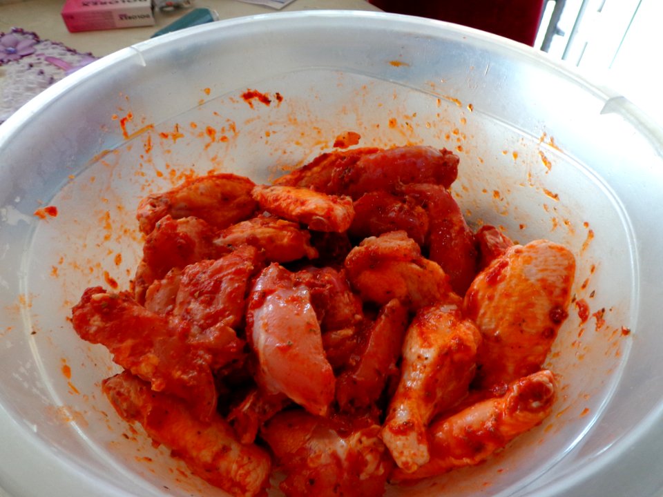 Uncooked chicken wings with sauce