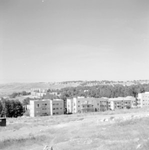 Uitzicht vanuit een heuvelig landschap op woonblokken, Bestanddeelnr 255-2440