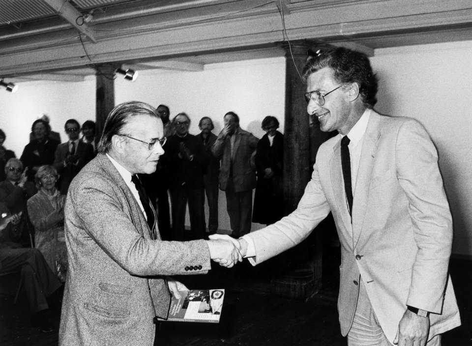 Uitreiking van het eerste exemplaar door Harry Mulisch aan Harry Prenen van Louis Ferron's boek De keldergang der heren over de geschiedenis van de sociëteit 'Teisterbant', NL-HlmNHA 54012345