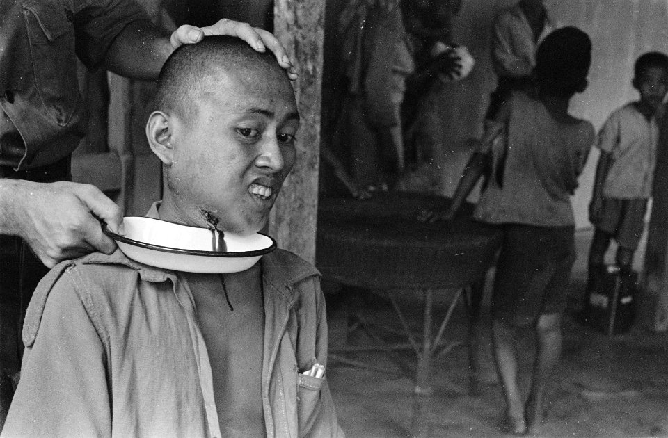 Uit de keel van een Indonesische man wordt bloed afgetapt, dat terecht kom in ee, Bestanddeelnr 503-4-2
