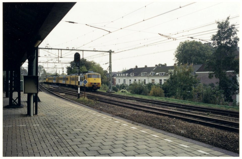 Uiterst westelijk deel van Station Haarlem met een sprinter-trein richting Beverwijk. Tussen de spoorlijn en de huizen aan het Staten Bolwerk-Prinsen Bolwerk komt een geluiddscherm. NL-HlmNHA 54037139