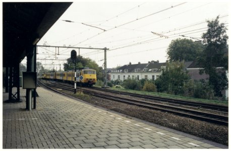 Uiterst westelijk deel van Station Haarlem met een sprinter-trein richting Beverwijk. Tussen de spoorlijn en de huizen aan het Staten Bolwerk-Prinsen Bolwerk komt een geluiddscherm. NL-HlmNHA 54037139